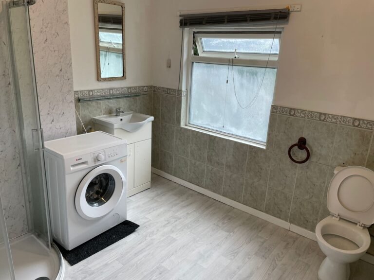 HMO shared bathroom after clean — vanity, shower and washer area sanitised.