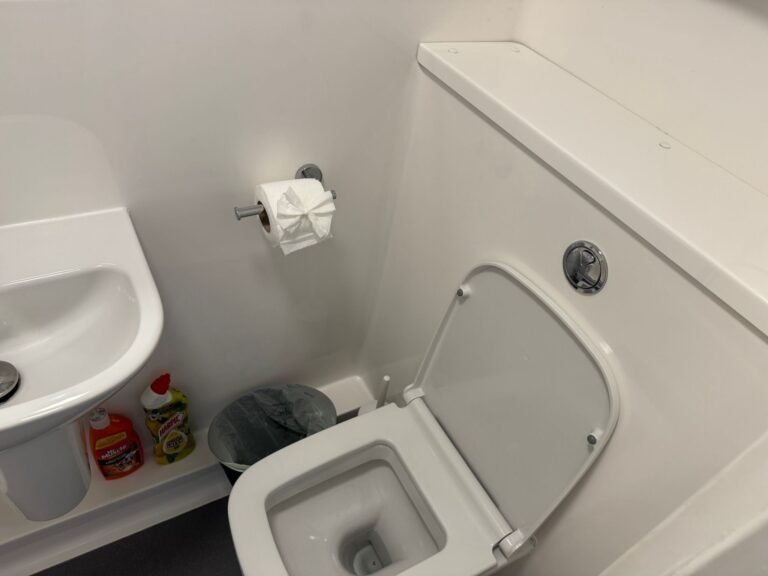 Student bathroom after end-of-tenancy clean — fixtures sanitised, presentation fold on paper.