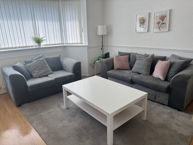 Airbnb lounge after turnaround — sofas staged, surfaces wiped, floors vacuumed.